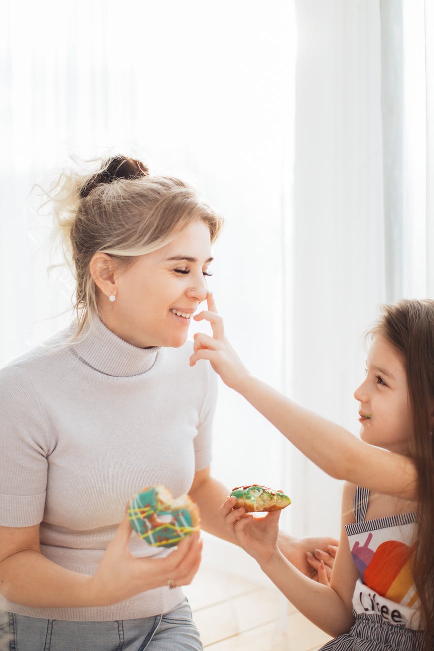 photo of a kid touching the nose of her mother