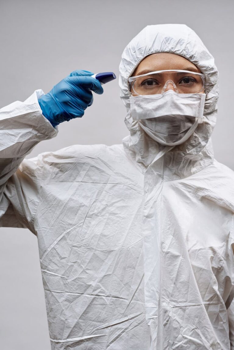 person wearing safety goggles and blue latex gloves standing