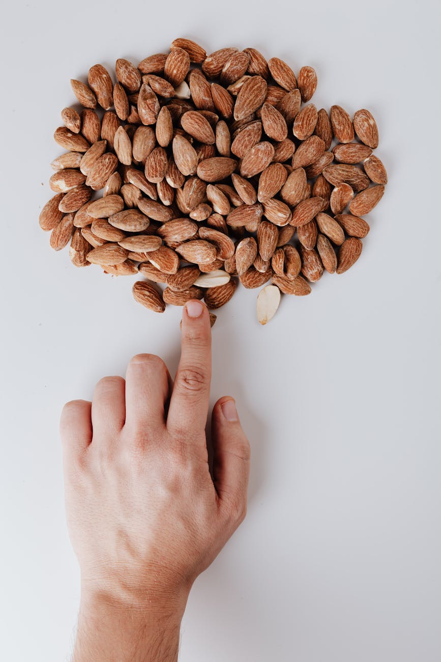 person hand pointing on almonds