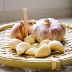 a basket of garlic and garlic bulbs on a counter