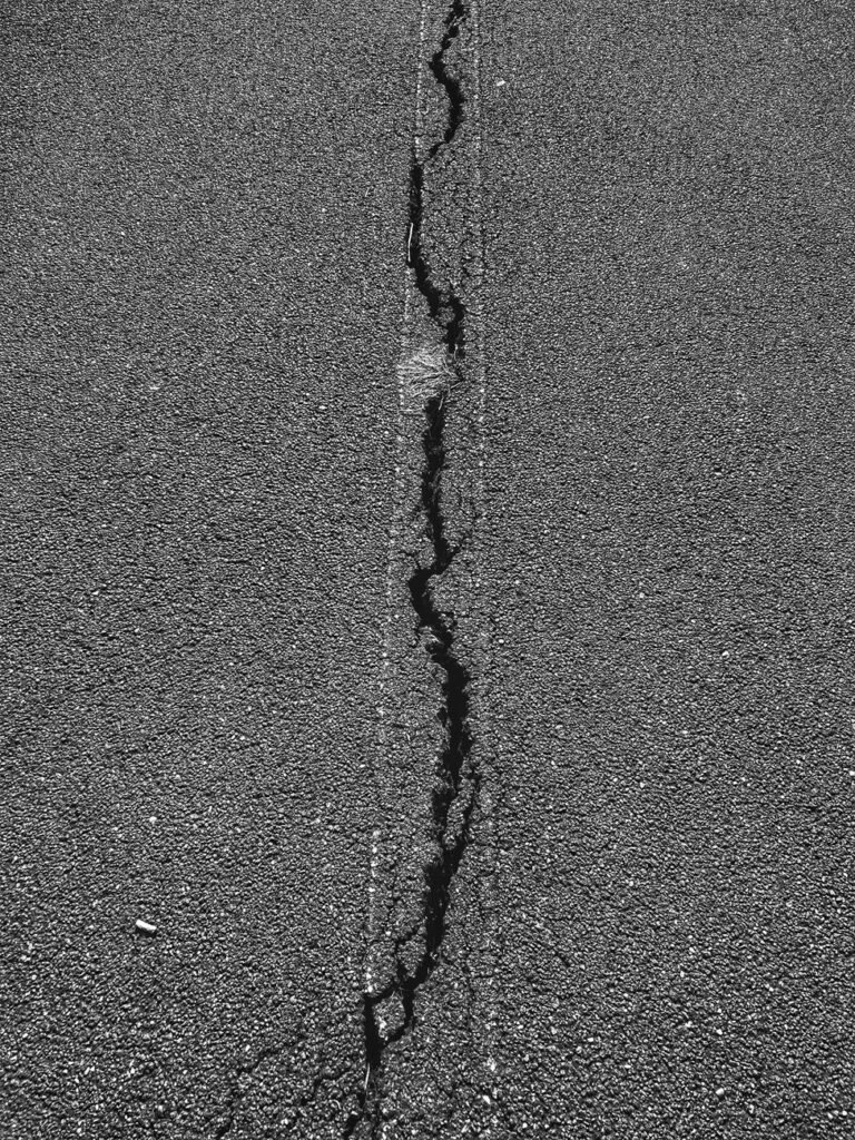 close up of a cracked asphalt road surface