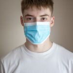unemotional young man wearing protective respirator