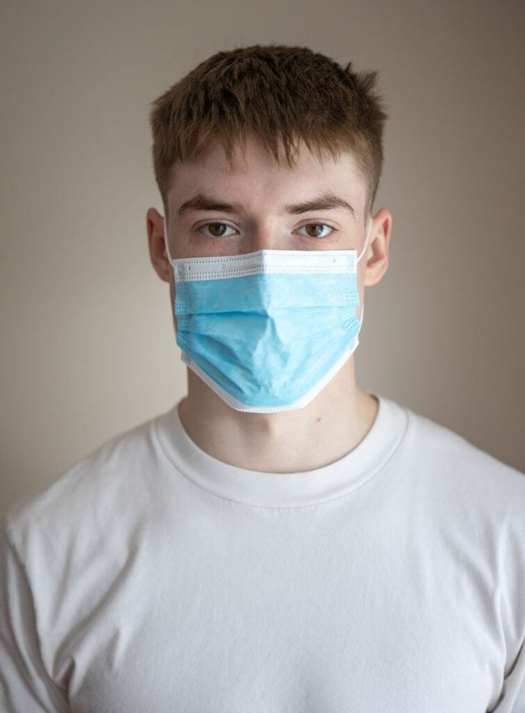 unemotional young man wearing protective respirator