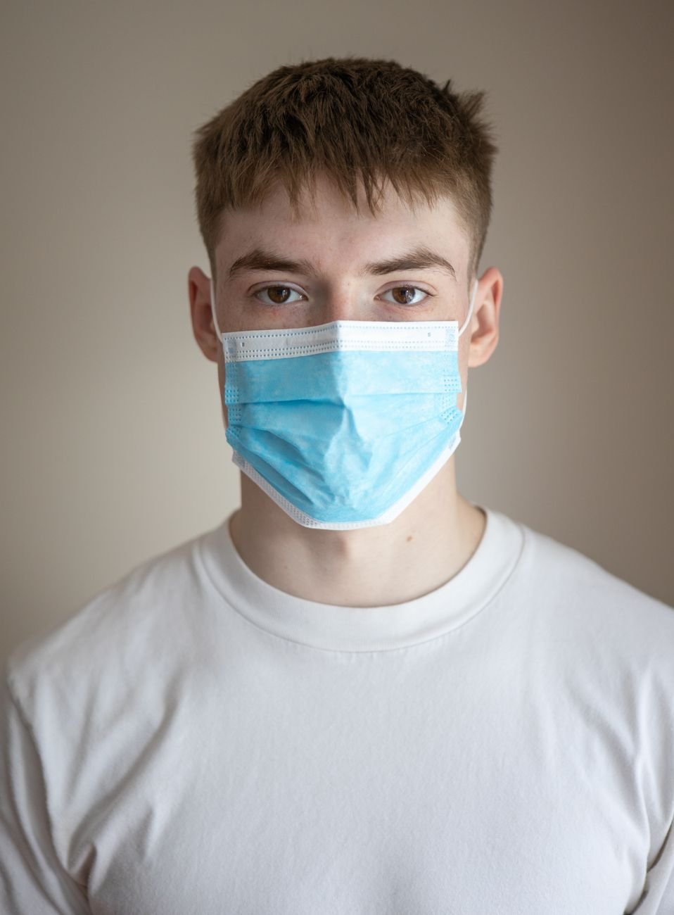 unemotional young man wearing protective respirator