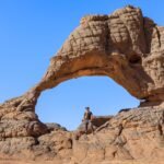 a person standing in front of a rock formation