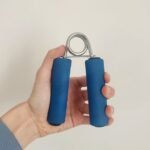 hand holding blue grip strength exercise tool