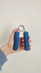 hand holding blue grip strength exercise tool