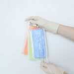 hands of a person holding disposable face masks